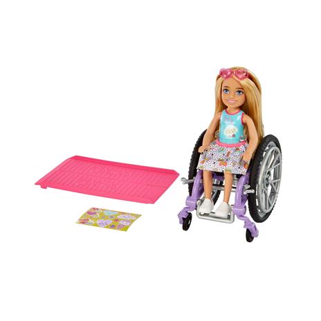 Barbie - Chelsea bambola bionda con sedia a rotelle, che indossa gonna e occhiali da sole, include rampa e foglio adesivi