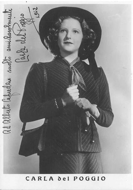 Fotografia dell'attrice in piedi con tailleur. Dedica e firma autografe con data - copertina